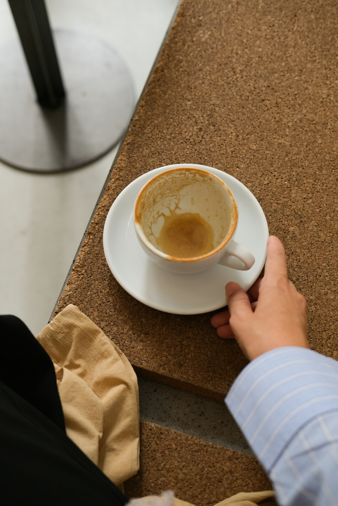 Person reading a newspaper with economic news at a café table